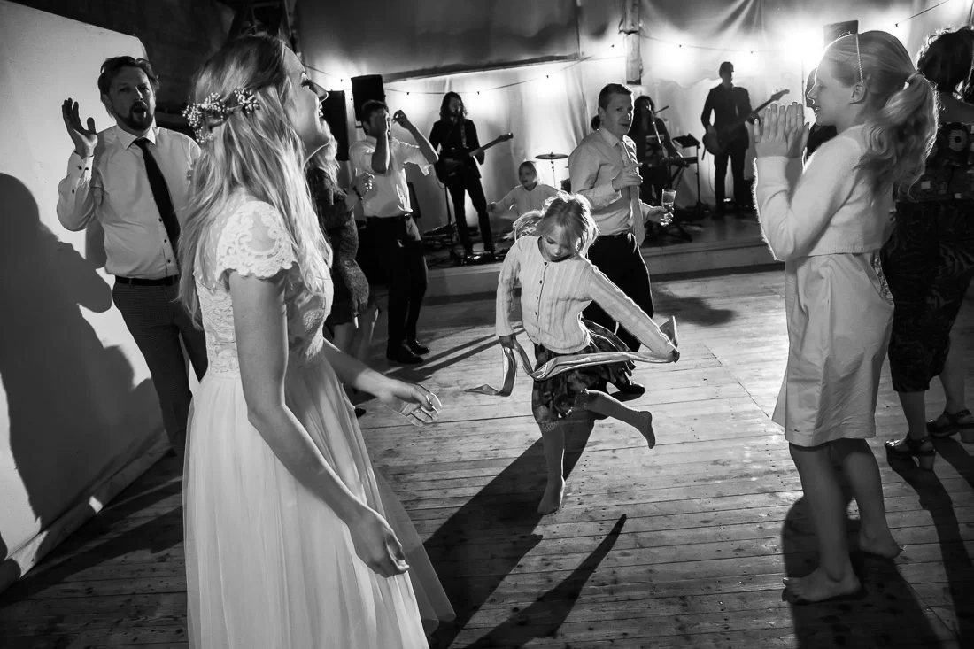 brollop-i-borgeby-slott-120 Bruden dansar med gäster och ett barn framför liveband på dansgolvet under festen på Borgeby Slott – bröllopsfotograf Lund