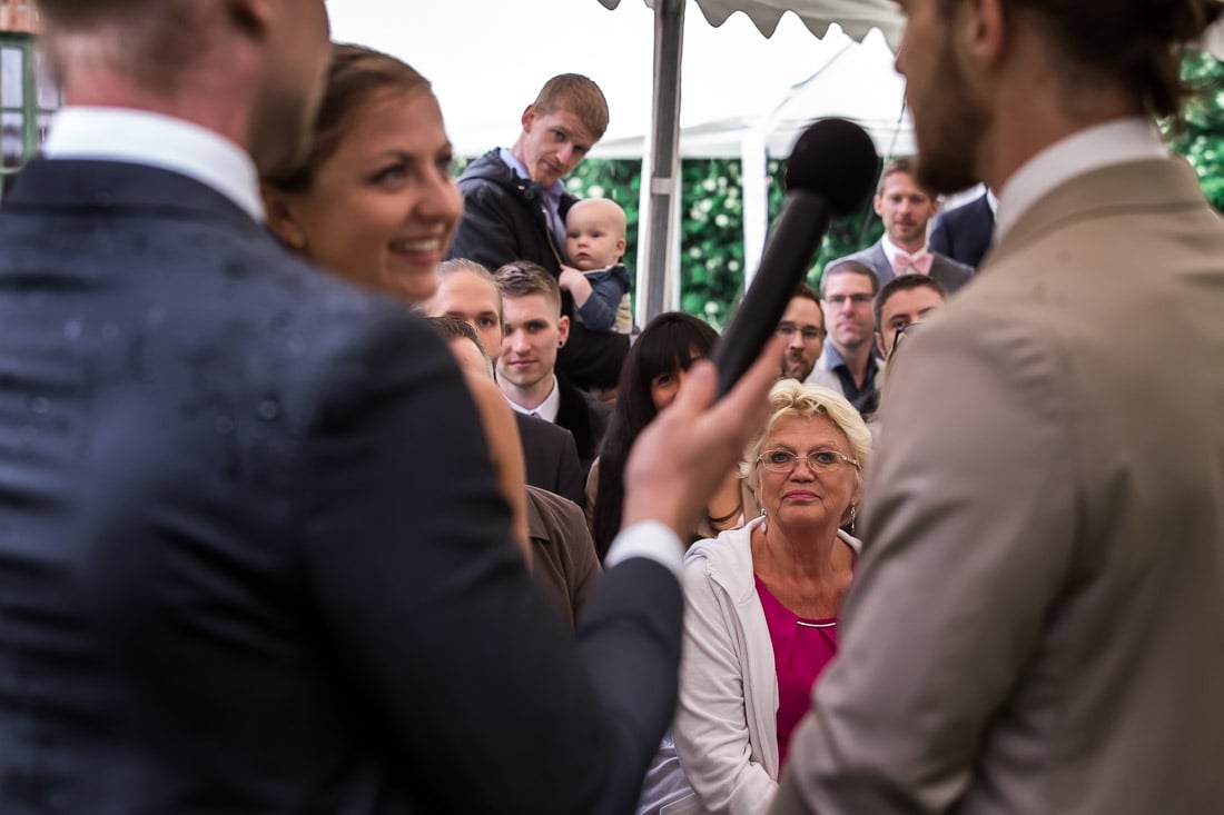 Gäster följer vigseln Bröllopsgäster följer brudparets löften under vigseln – bröllopsfotograf Skåne