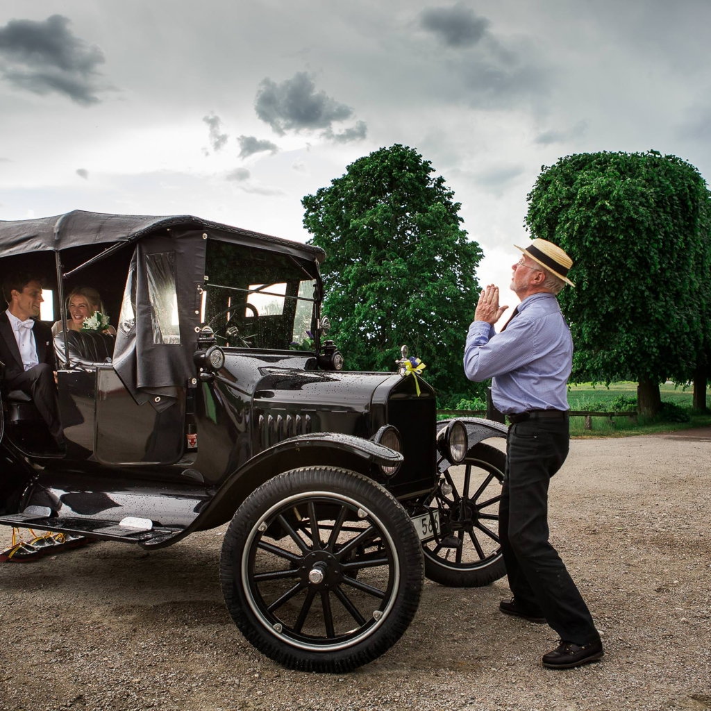 Vigselfotograf Skåne – vintagebil och brudpar på väg från vigseln