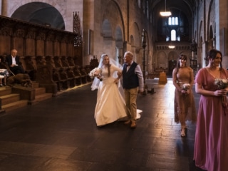 V&auml;n kramar bruden vid domkyrkans bronsd&ouml;rrar efter vigseln &ndash; br&ouml;llopsfotograf Lund