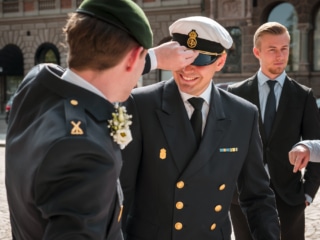 G&auml;ster i marinuniform sitter vid det dukade bordet &ndash; br&ouml;llopsfotograf Lund