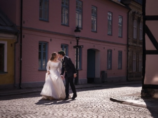 Brudgummen kysser bruden p&aring; kinden vid middagsbordet &ndash; br&ouml;llopsfotograf Lund