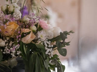 Bordsblommor i pastell p&aring; det dukade middagsbordet &ndash; br&ouml;llopsfotograf Lund