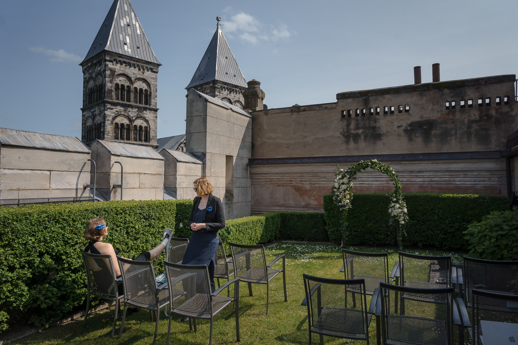 Ceremonin förbereds Vigselplats med blomsterbåge på takterrass, Lunds domkyrka bakom – bröllopsfotograf Lund