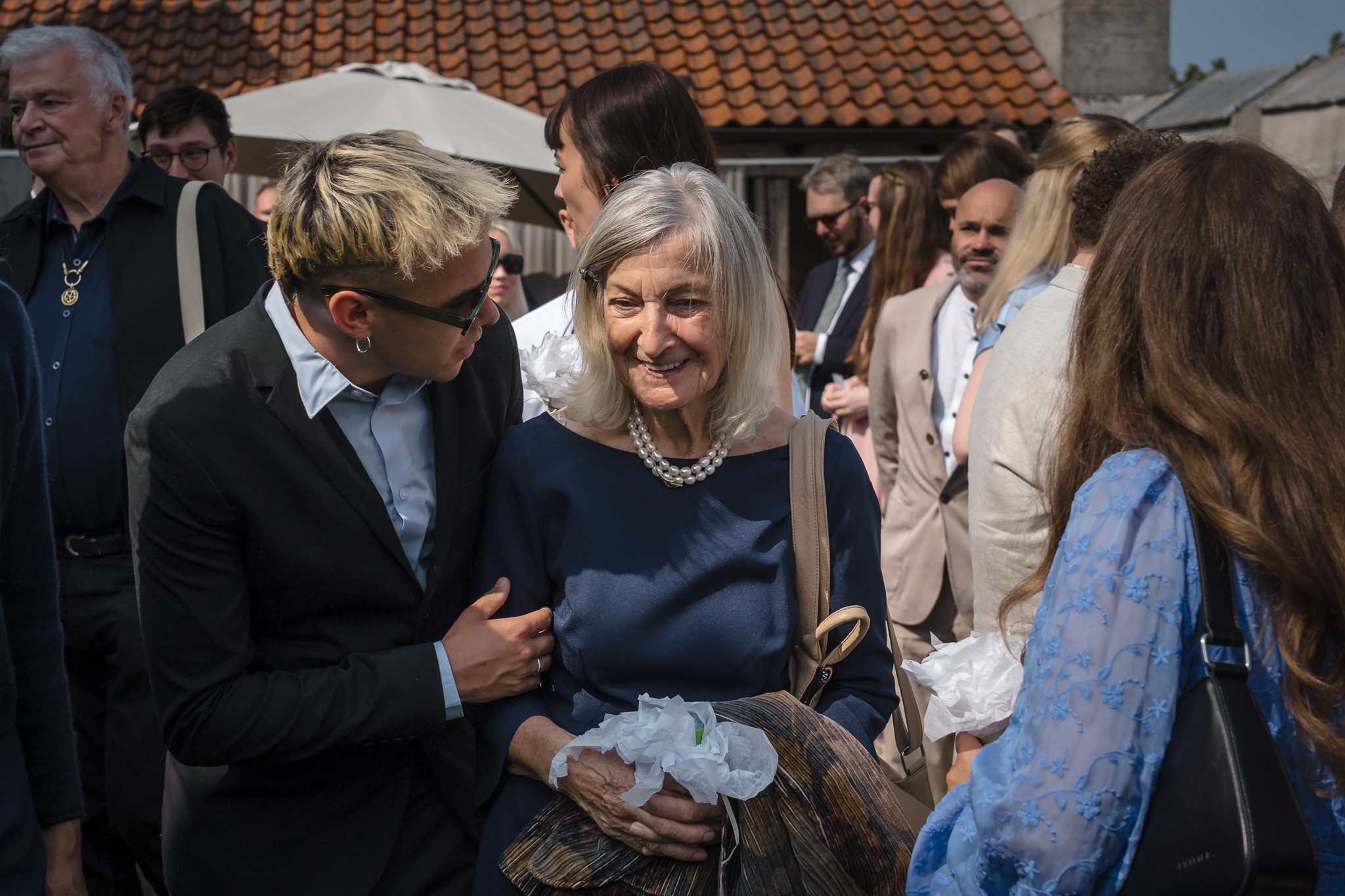 Mingel i solen Bröllopsgäster minglar i solen på takterrassen på Hypoteket – bröllopsfotograf Skåne