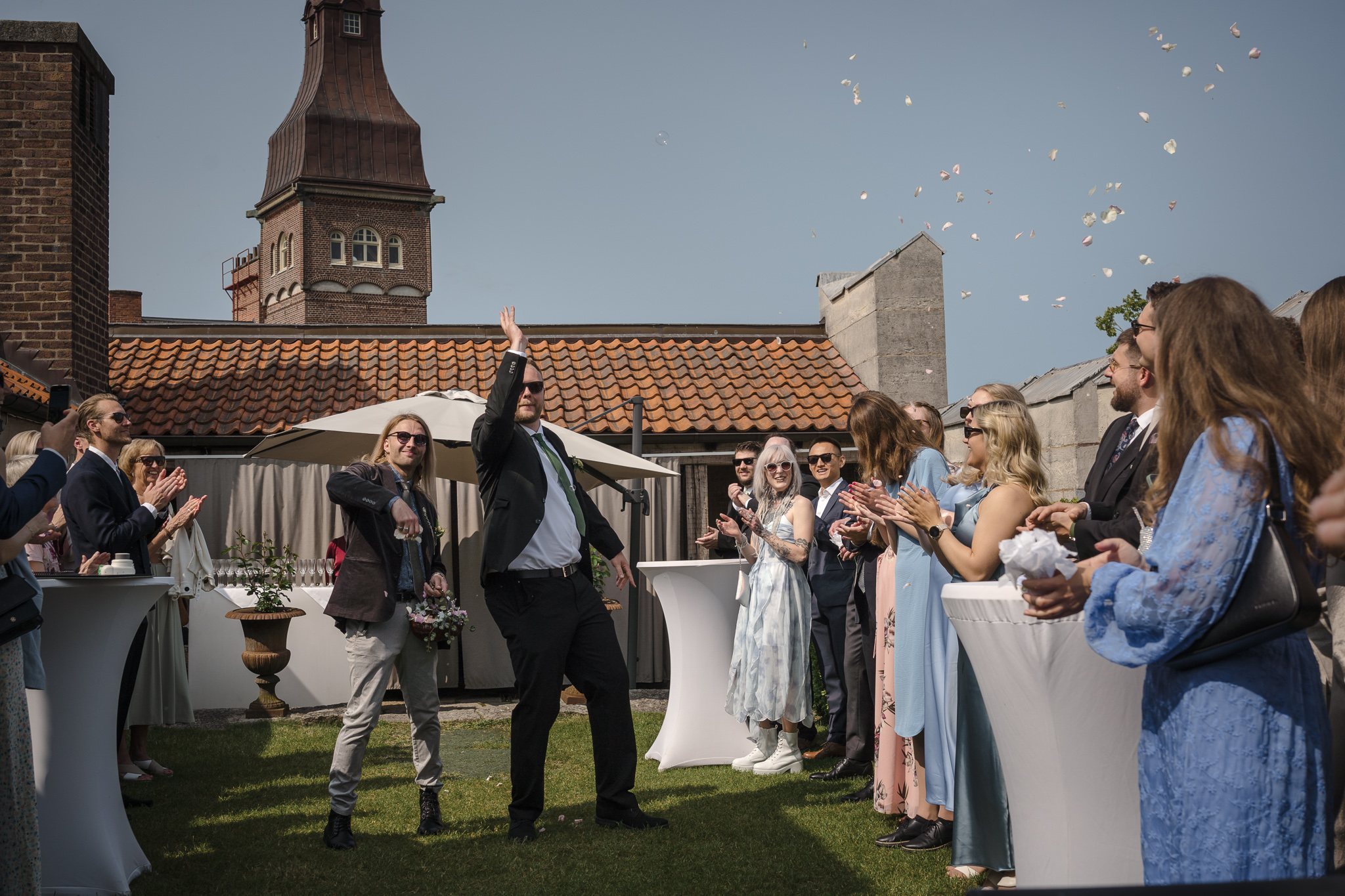 Rosenblad i luften Best man kastar rosenblad vid vigseln på takterrassen – bröllopsfotograf Lund