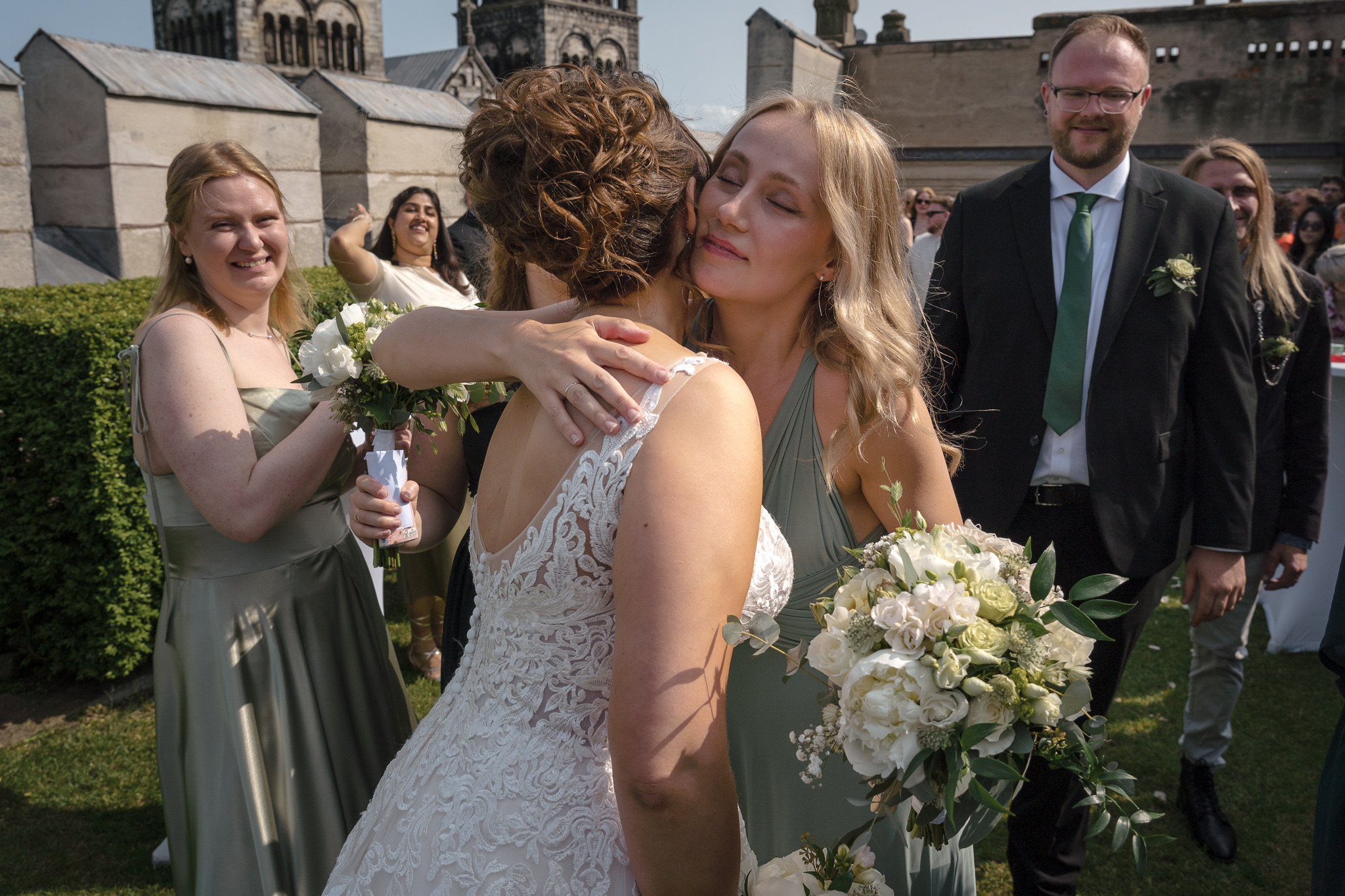 Gratulationer Tärna kramar bruden och gratulerar efter vigseln – bröllopsfotograf Skåne