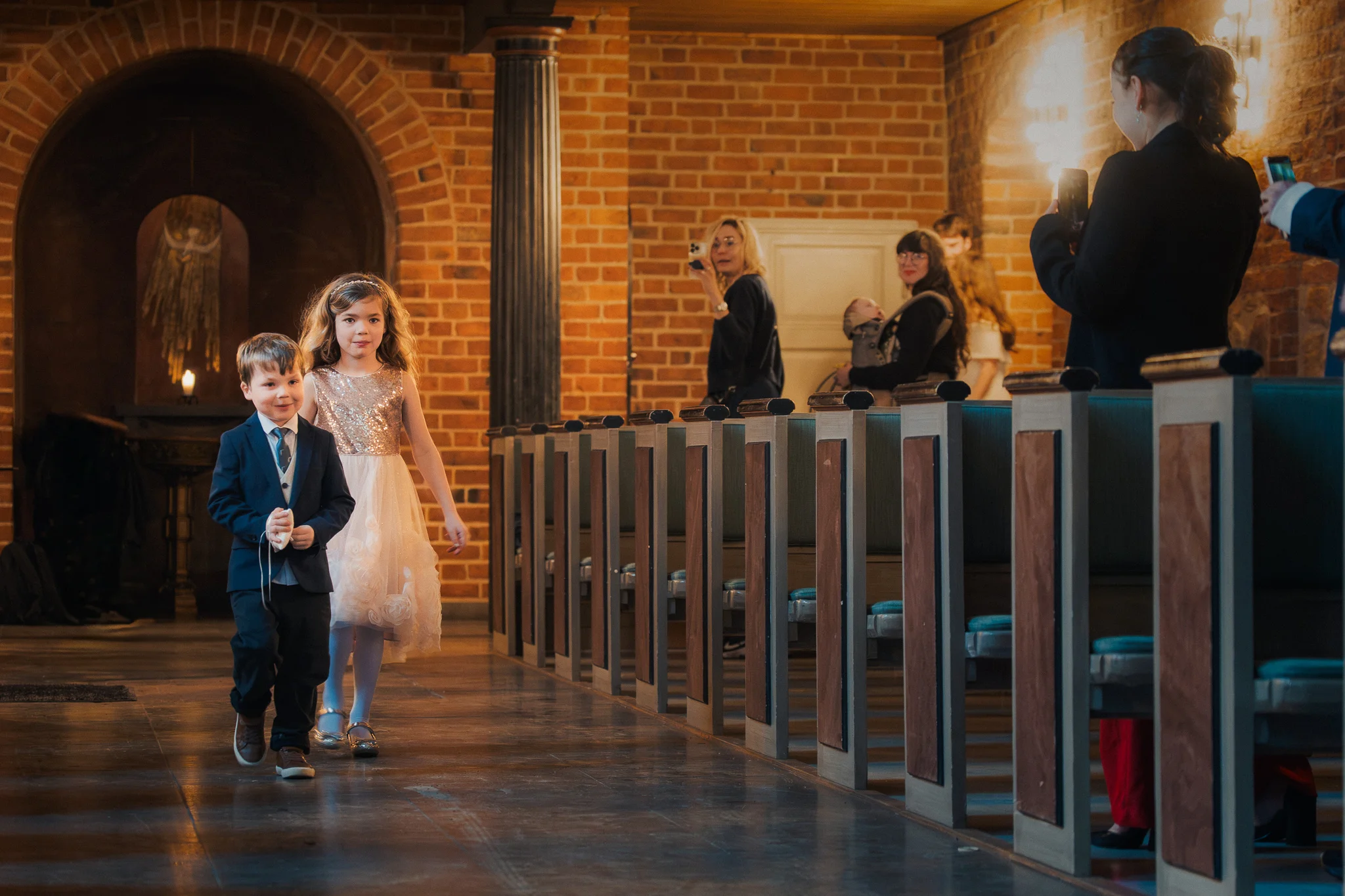 Barnen går in i kyrkan Blomsterflicka och ringbärare går in längs gången i Klosterkyrkan i Lund – bröllopsfotograf Lund