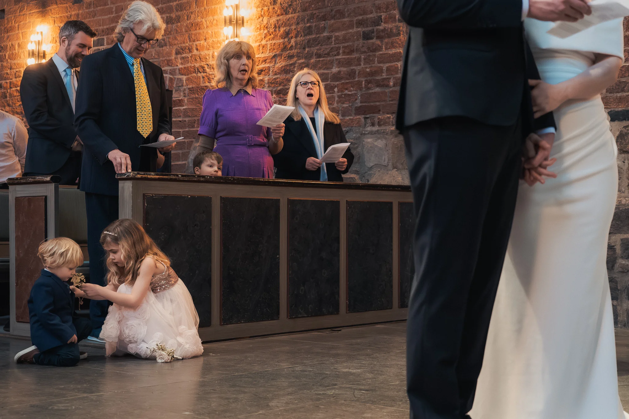 Barnen på golvet Barn leker på golvet under vigseln i Klosterkyrkan i Lund – bröllopsfotograf Lund