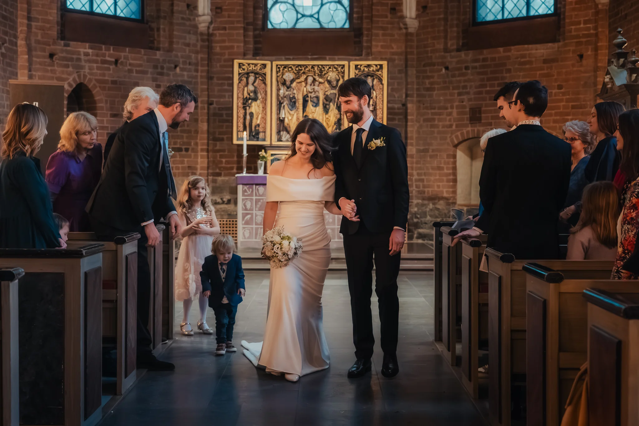 Ut ur kyrkan Bruden och brudgummen går ut ur Klosterkyrkan efter vigseln i Lund – bröllopsfotograf Lund