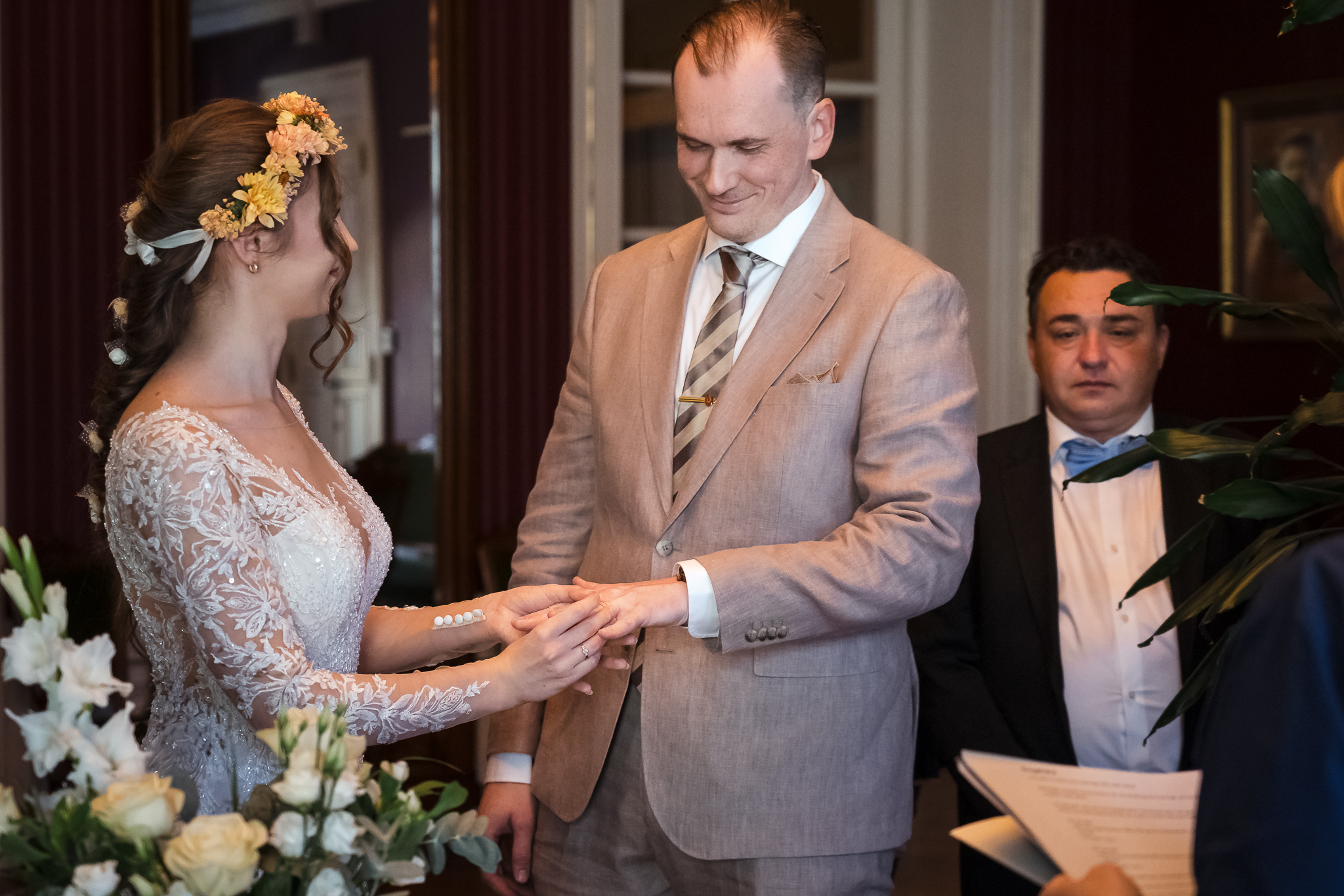 Ringväxlingen Bruden sätter vigselringen på brudgummens finger vid ceremonin på Malmö Rådhus – bröllopsfotograf Malmö